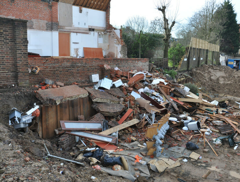 A collapsed wall that has taken the wall down of the neighbouring property