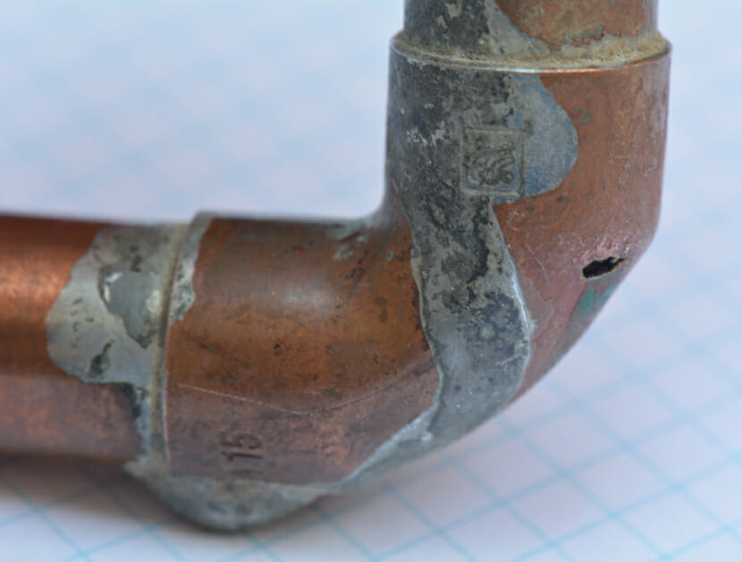 Close-up on a pipe bend and a soldered joint