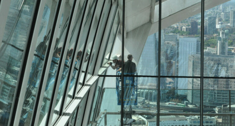 Two acoustical engineers inspecting a large high-rise building