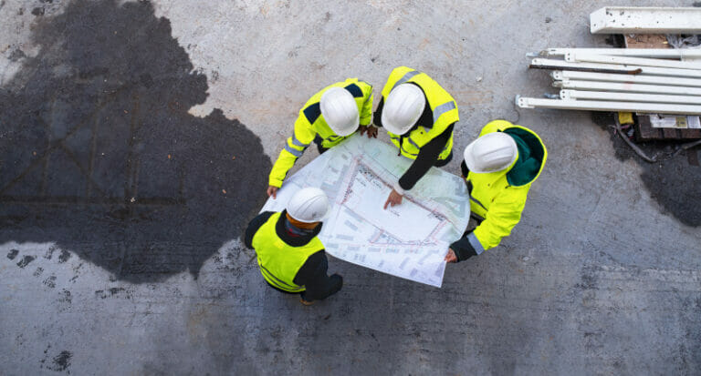 Four investigators looking at the plans of a building