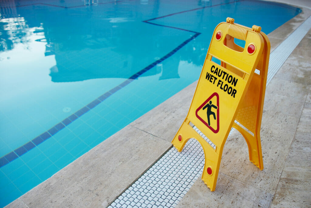 danger sign next to a swimming pool