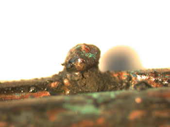 A raised bead on a conductor that was visible at the fire scene without magnification.