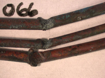All three conductors of this cable were involved. The arcing had occurred at a fixing screw. All are notched with beading on the notch edges.