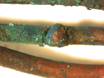 A bead within a notch on the conductor. The demarcation between the melted and un-melted conductor metal is visible.