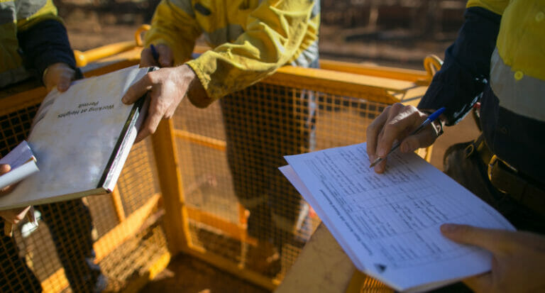 Miner supervisor checking reviewing document before issued sigh