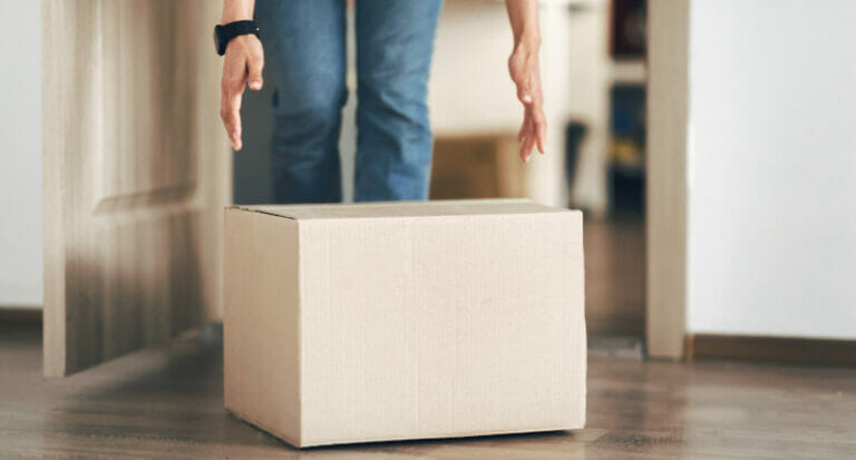 Unrecognizable person picking cardboard box up