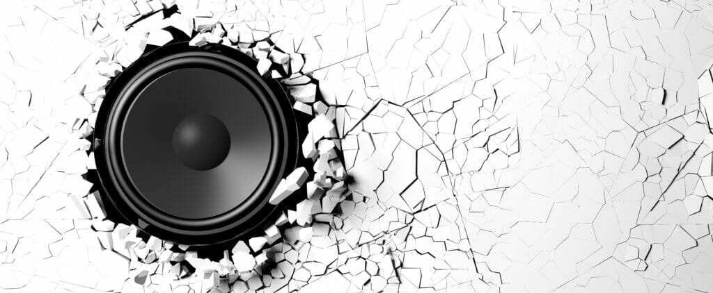 Image of speaker surrounded by broken glass having shattered through noise and vibration exposure