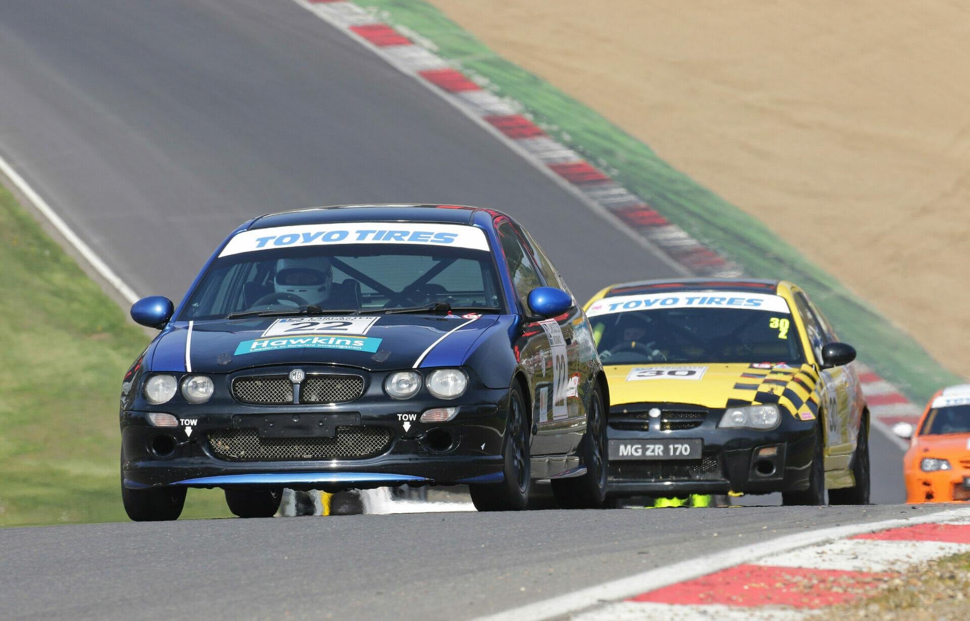 Picture of two cars racing around a rally track. James Wade is driving one of them at an event.