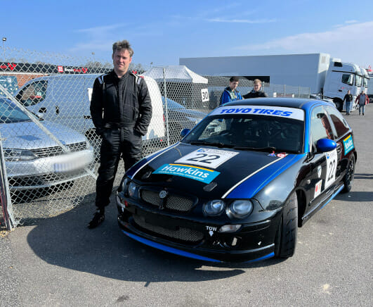 James Wade poses for a picture in front of his rally car at his recent car racing event