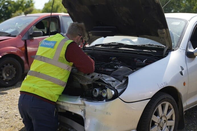 Hawkins inspecting damaged vehicle 1