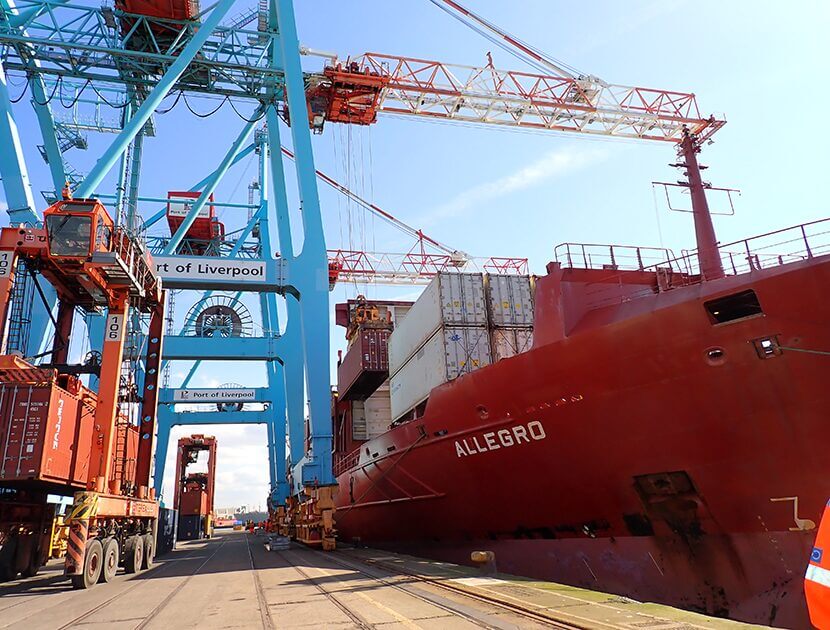 Large container ship docked at port with hull showing