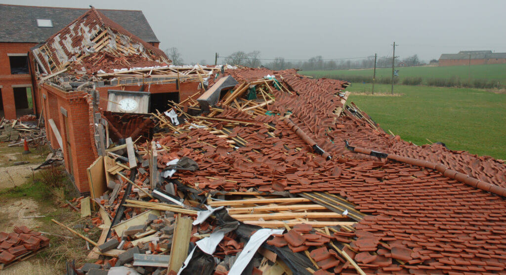 Collapsed red brick home in field
