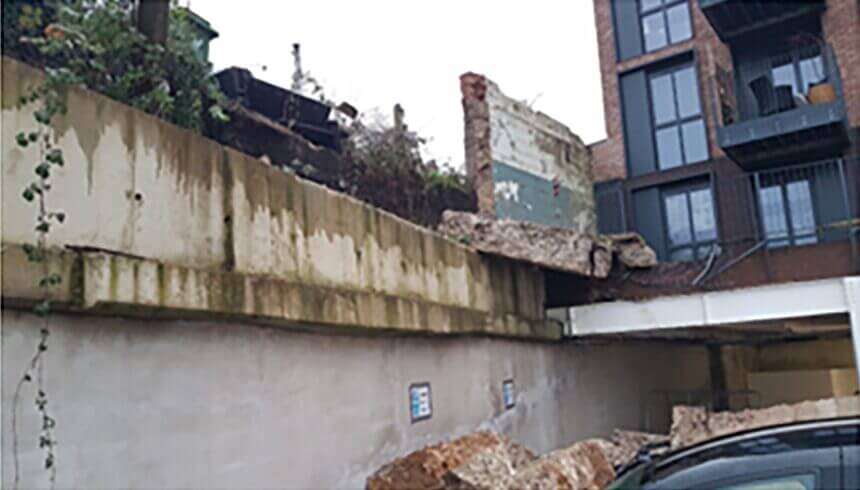 Partial wall collapse in front of a building