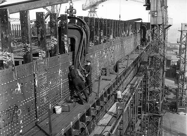 Workers installing rivets in the hull of Titanic in 1911 at the Harland & Wolff Shipyard in Belfast, Ireland