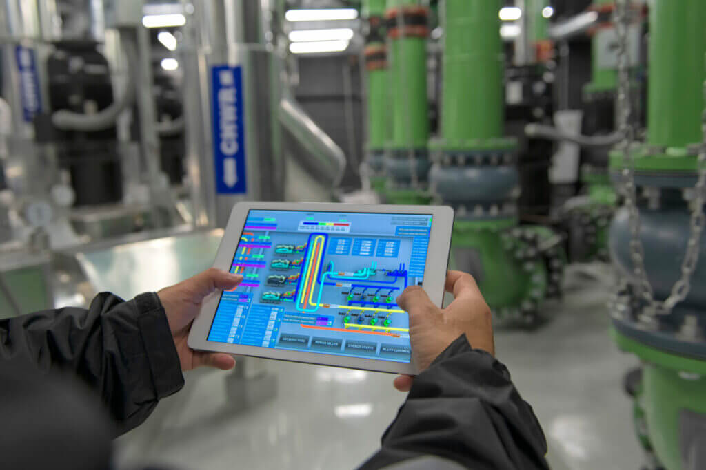 Person using a tablet on chiller water pump for HVAC system on background. person working on a digital tablet on air condition system plant.