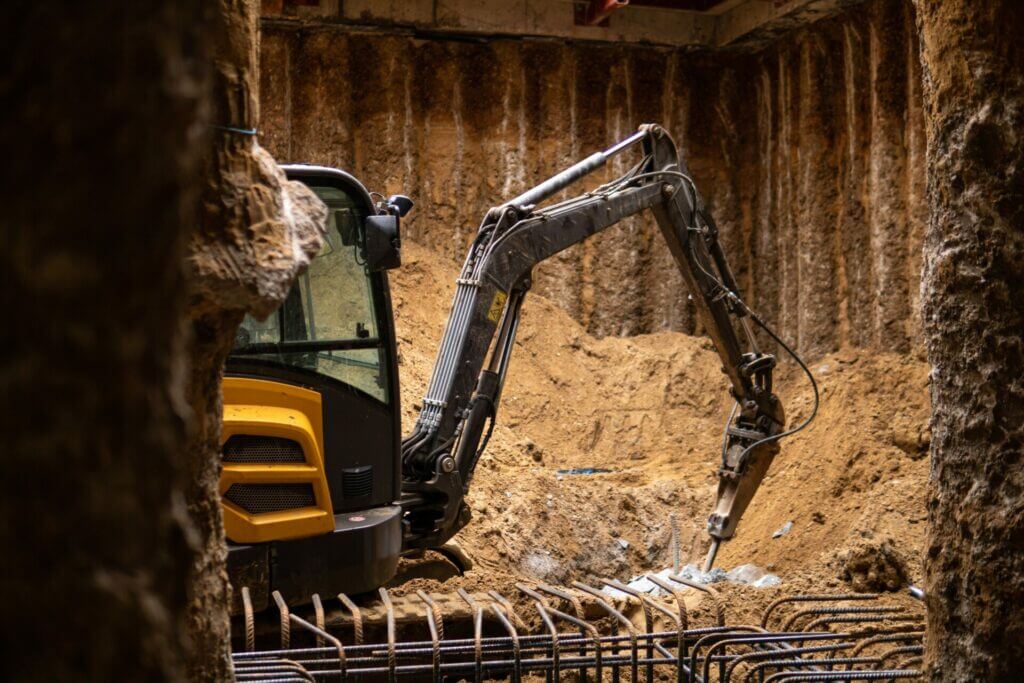 Excavator in secant walled basement