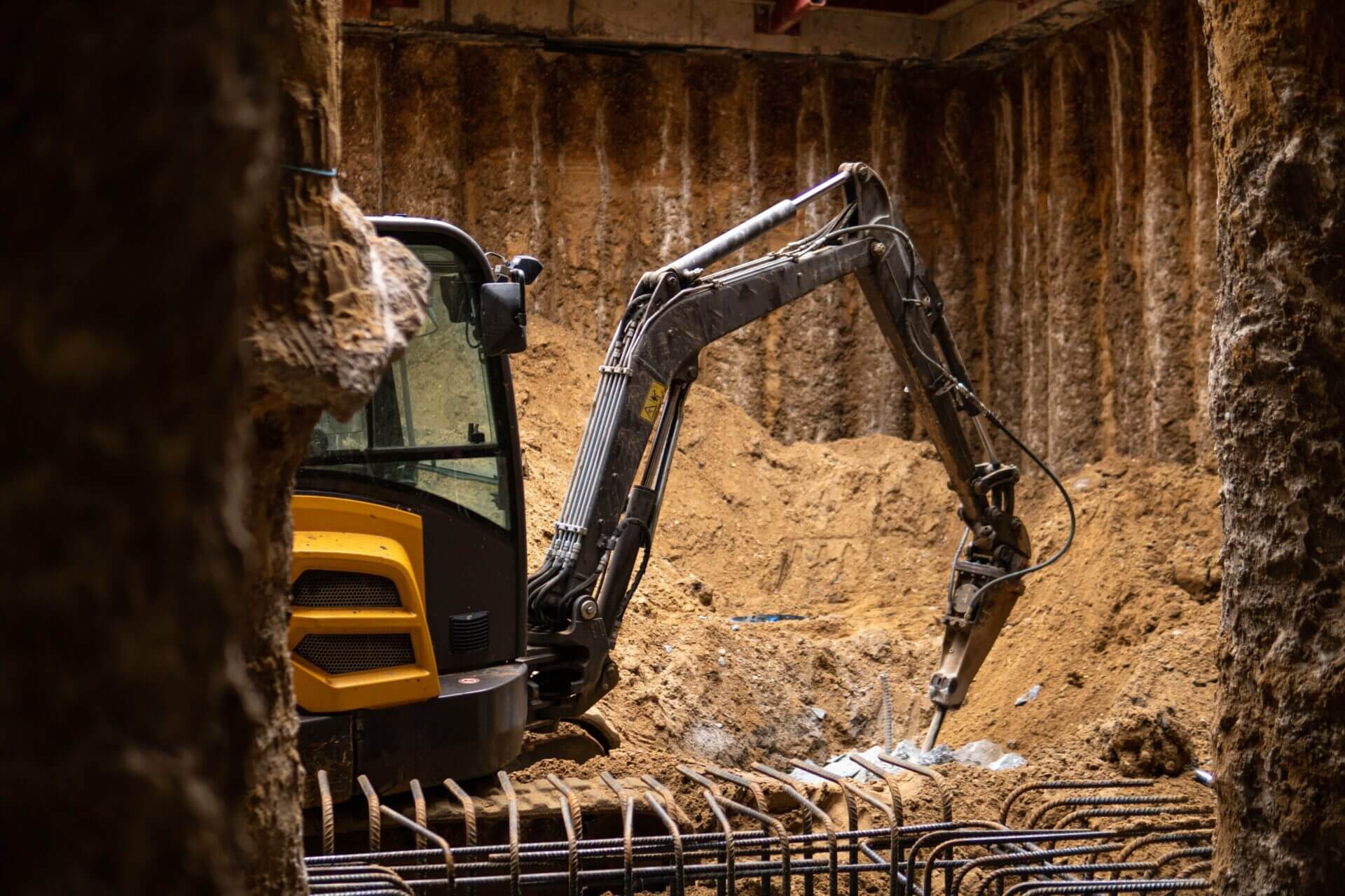 Excavator in secant walled basement